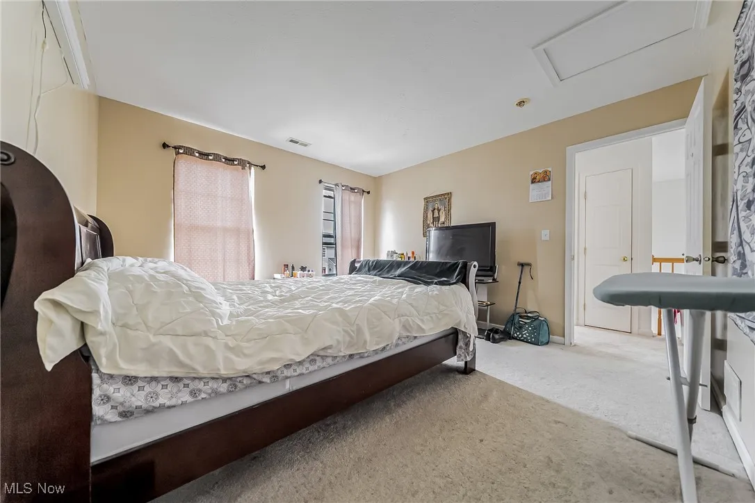 Bedroom featuring carpet floors and attic access