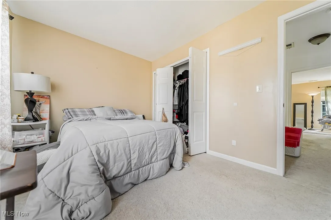Carpeted bedroom featuring vaulted ceiling and a closet