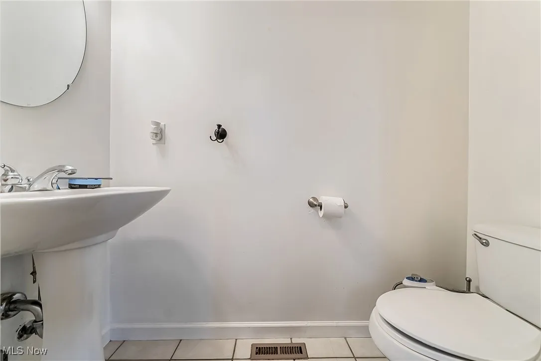 Half bath featuring tile patterned floors and toilet