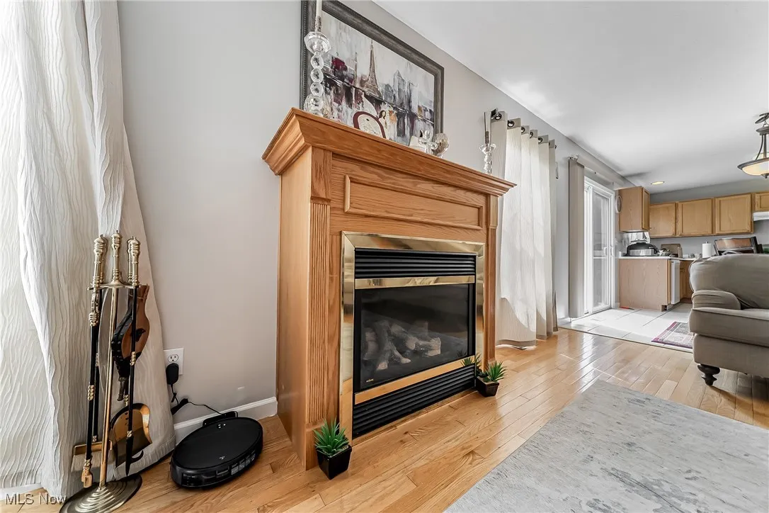 Living room featuring light wood finished floors and a glass covered fireplace