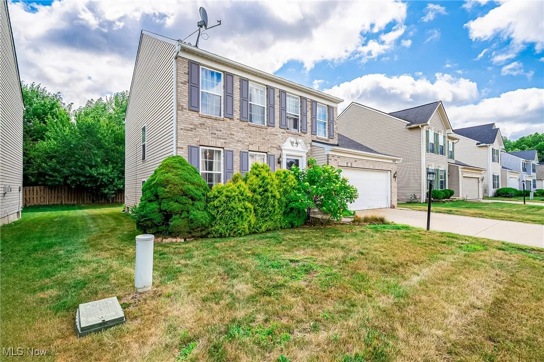 Colonial inspired home with driveway, a residential view, a front yard, and an attached garage