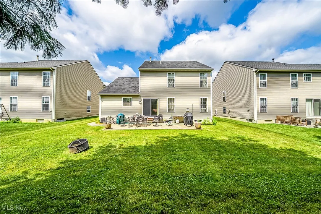 Back of house with an outdoor fire pit, a yard, and a patio area