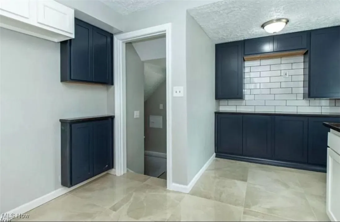 Kitchen with tasteful backsplash and a textured ceiling