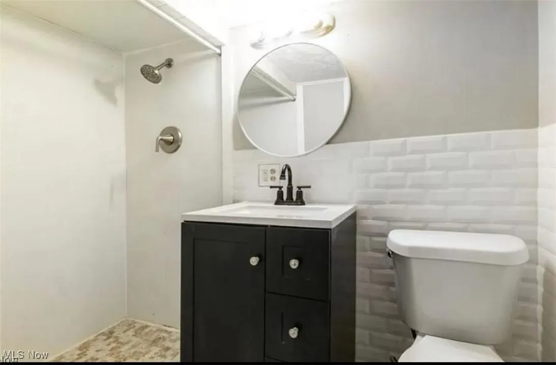 Bathroom with vanity and tile walls