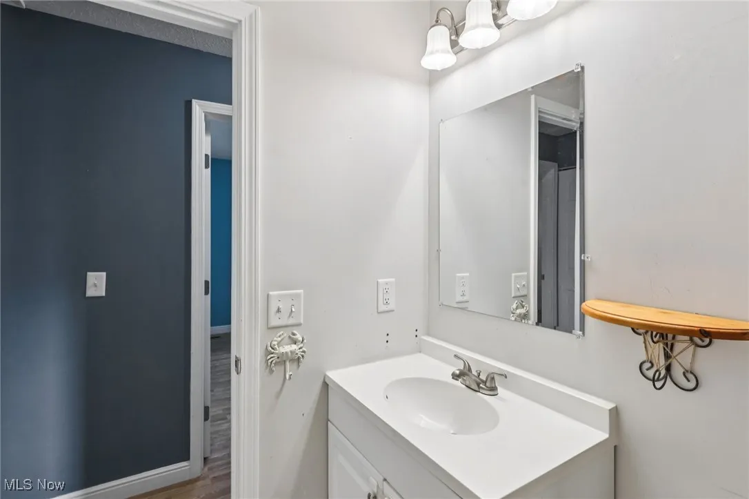 Bathroom with vanity, wood finished floors, and a chandelier