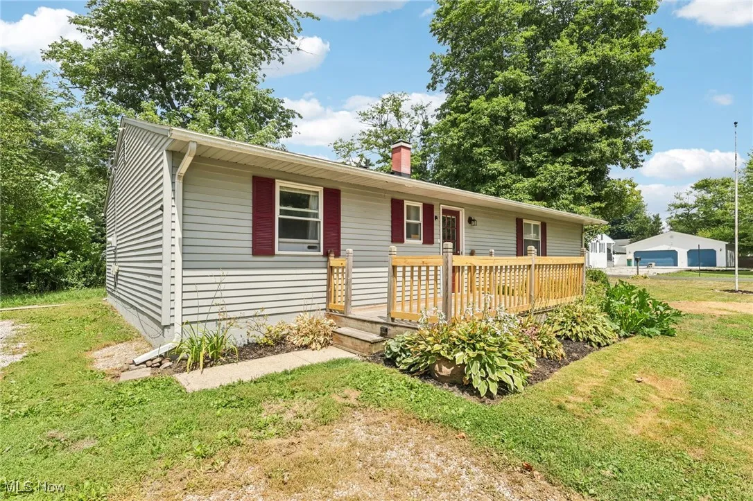 Single story home with a deck, a front yard, and a chimney