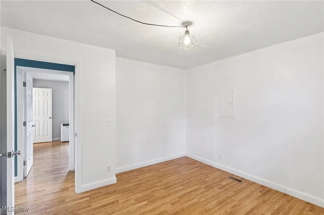 Spare room with light wood-style floors and a textured ceiling