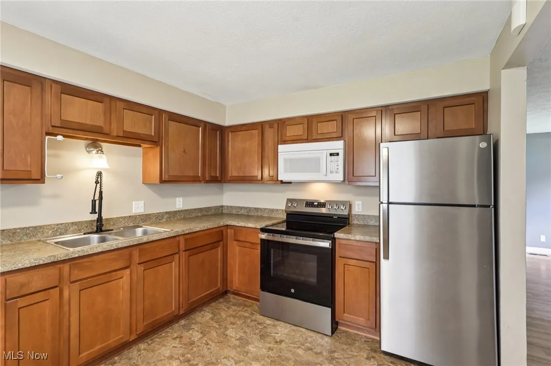 Kitchen with stainless steel appliances and brown cabinetry