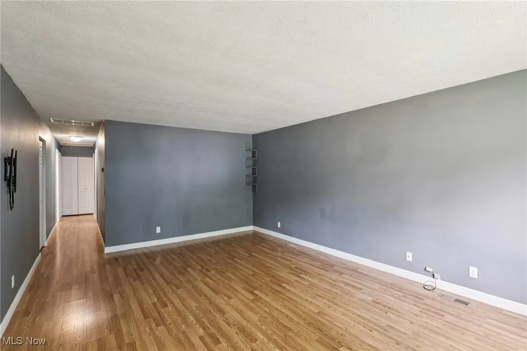 Empty room with wood finished floors and a textured ceiling