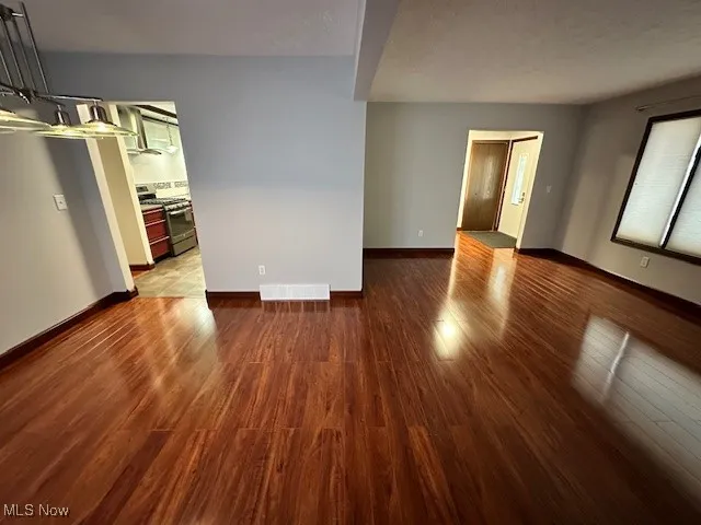 Empty room featuring wood finished floors and baseboards