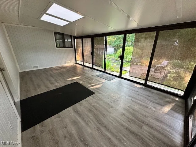 Unfurnished sunroom with a skylight