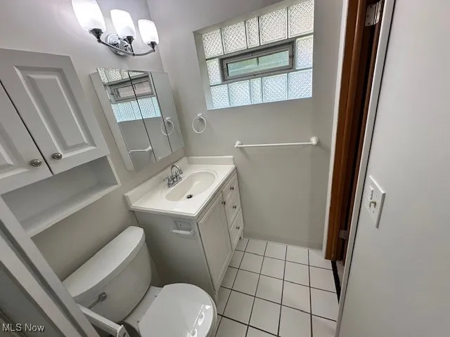 Bathroom featuring tile patterned floors, plenty of natural light, and vanity