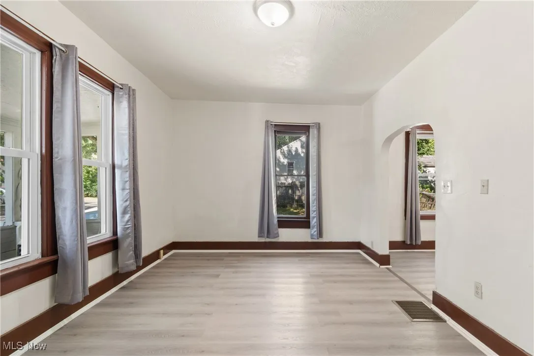 Unfurnished room with light wood-style floors and arched walkways