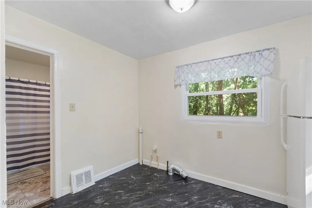 Laundry room with baseboards and dark marble finish floors