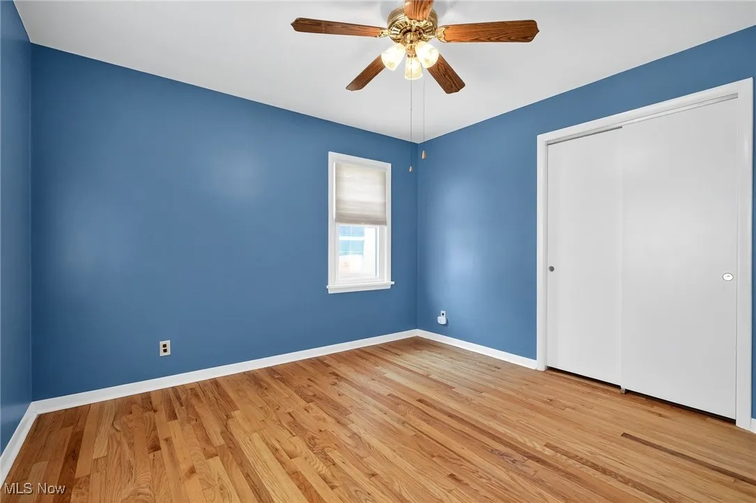 Unfurnished bedroom featuring wood finished floors, a closet, and ceiling fan