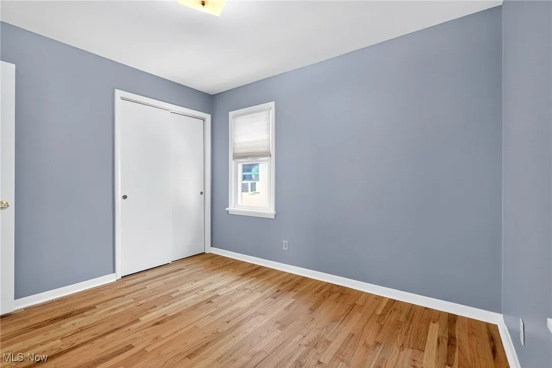 Unfurnished bedroom featuring light wood finished floors and a closet