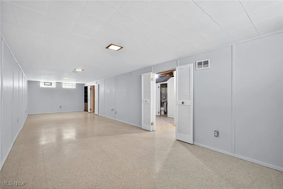 Empty room featuring tile patterned floors and baseboards