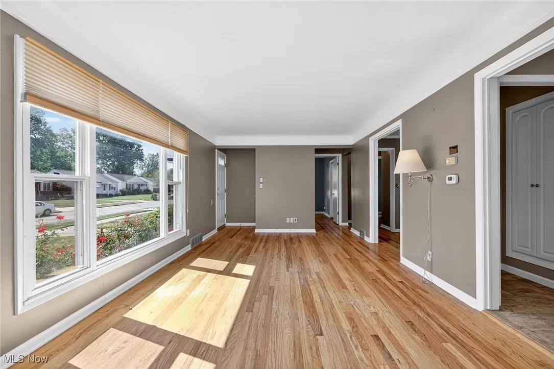 Unfurnished living room featuring baseboards and light wood-type flooring
