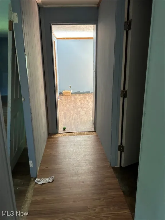 Corridor featuring dark wood-style floors