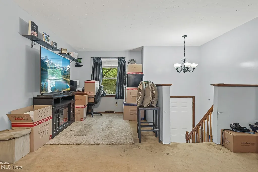 Carpeted family room with a chandelier