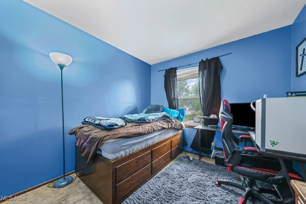 Bedroom featuring carpet flooring, an office area, and lofted ceiling