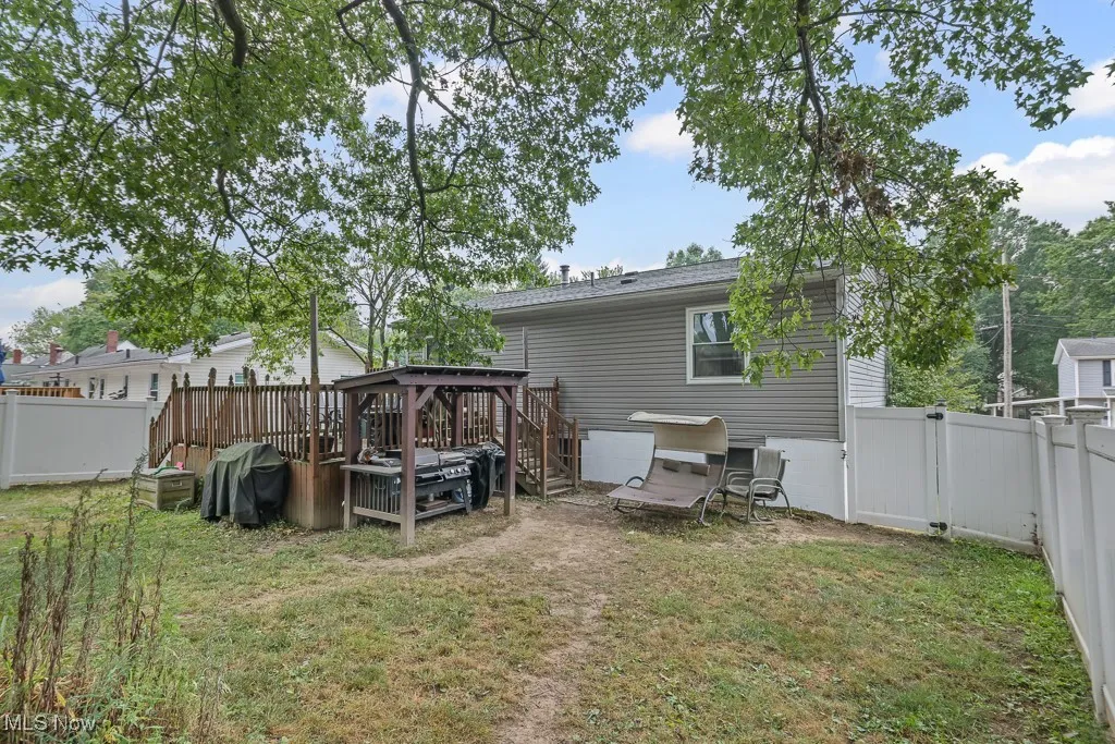 Back of house with a fenced backyard, a gazebo, a deck, and a gate