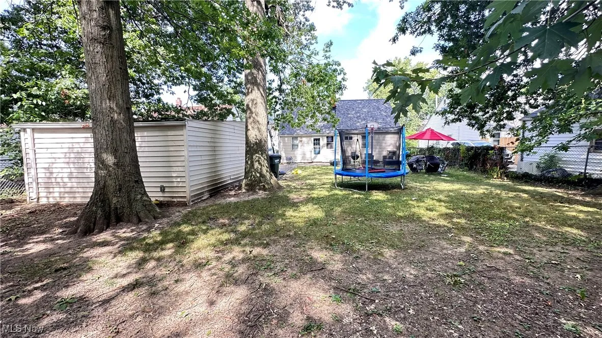 View of yard with a trampoline and a shed