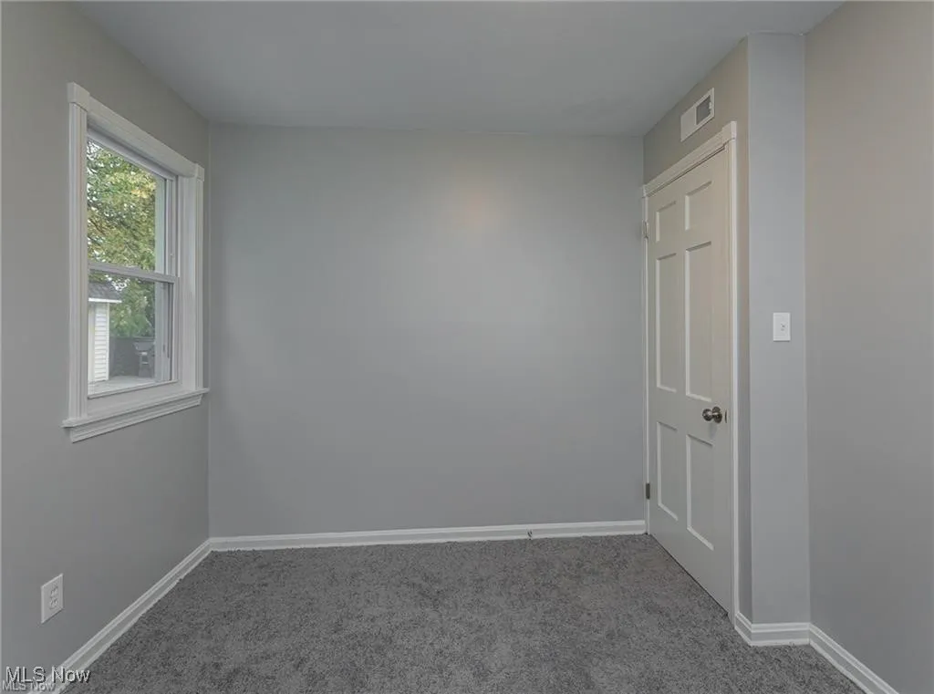 Carpeted spare room with baseboards