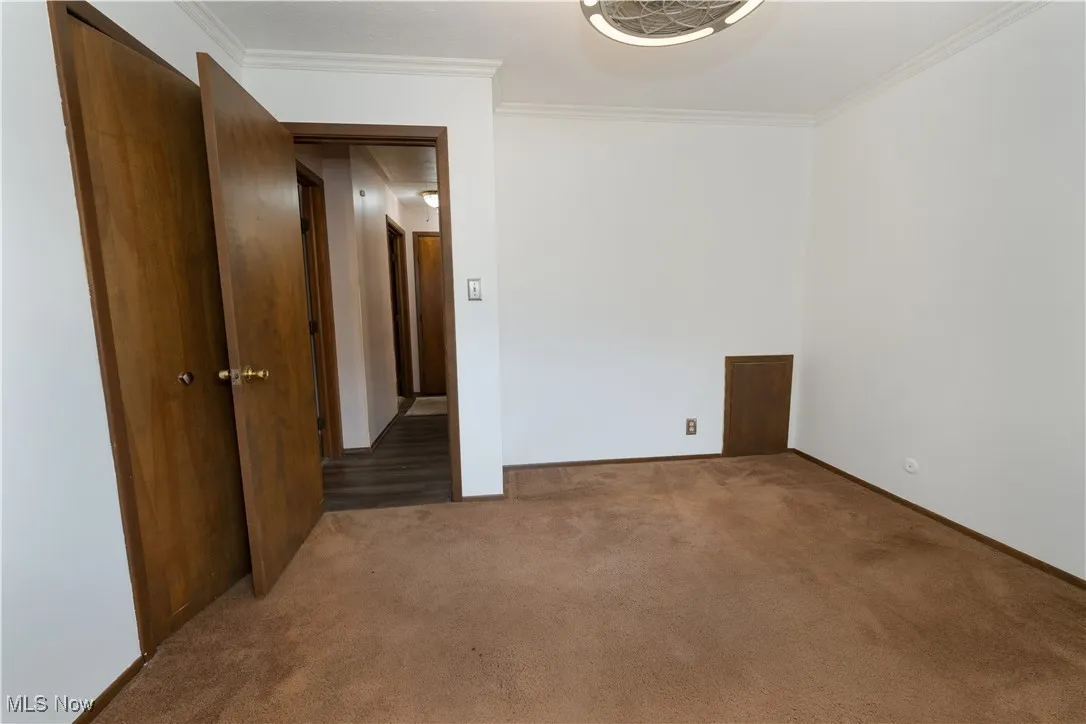 2nd bedroom featuring ornamental molding and carpet flooring