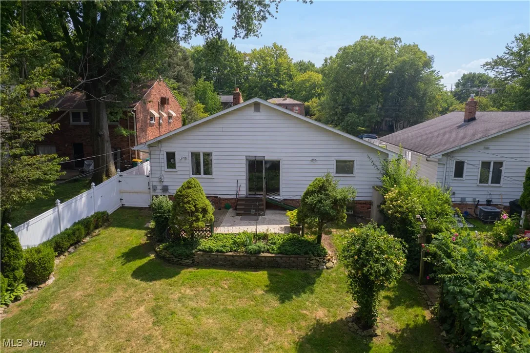 Back of house with a patio and view of scattered trees