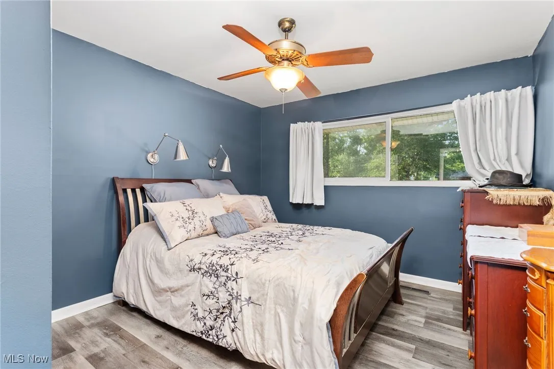 Bedroom with laminate floors and a ceiling fan