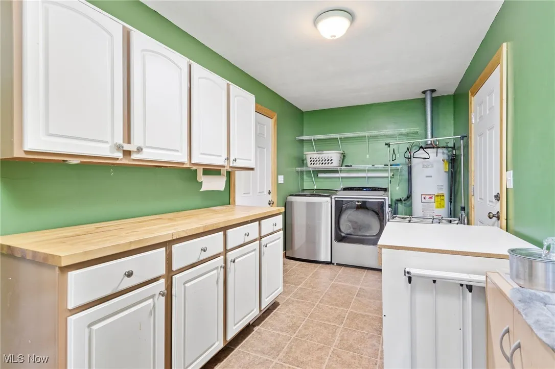 Laundry room view coming from kitchen with lots of cabinets, shelving & counter space , access to backyard & garage.