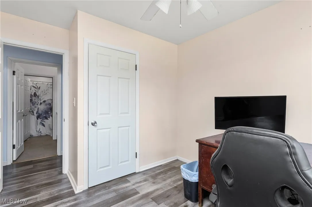 Bedroom with laminate flooring currently being used as an office.