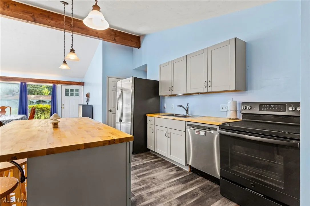 Updated Kitchen with butcher block countertops, stainless steel appliances, beamed ceiling, laminate flooring.