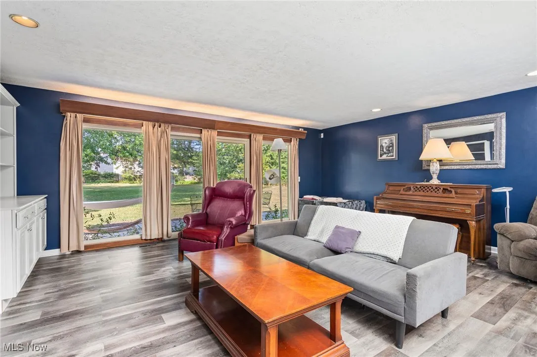 Living room with recessed lighting, laminate flooring, built in shelving and patio doors leading to new patio & fenced backyard.