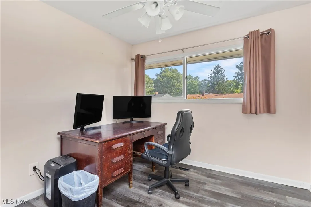 Bedroom with laminate flooring currently being used as an office.
