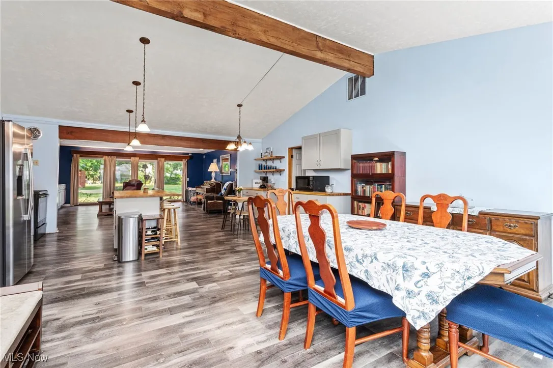 View from front door, featuring vaulted ceiling with beam, open floorplan.
