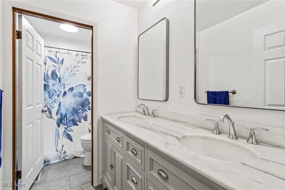 Updated Full bathroom featuring double vanity, tile patterned floors.