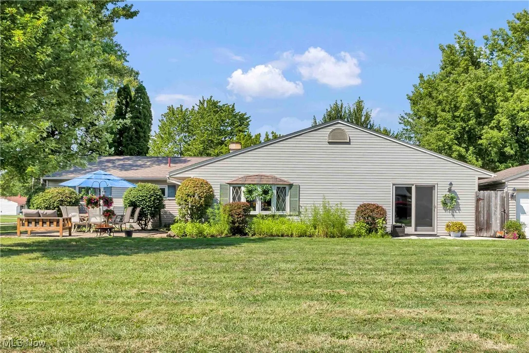 Rear view of house with a patio and a yard