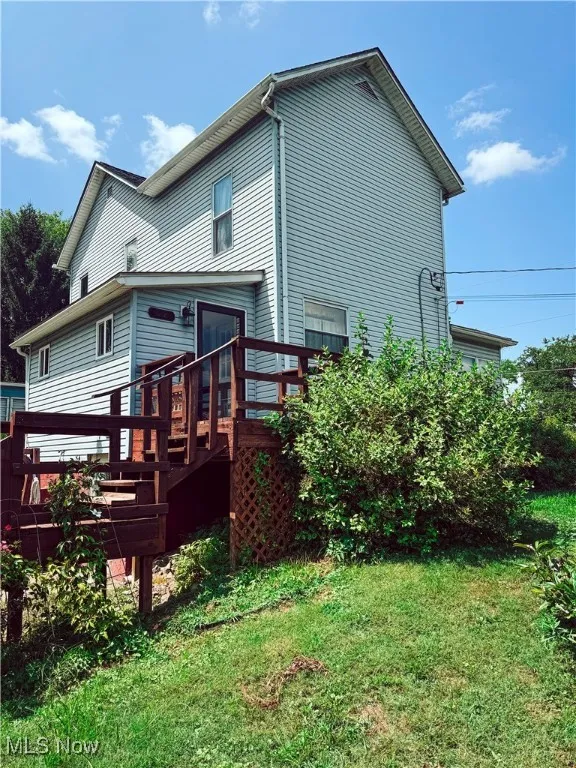 Back of house featuring a deck and a lawn