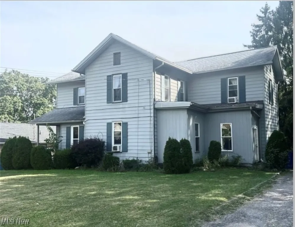 Traditional home featuring a front lawn and roof with shingles