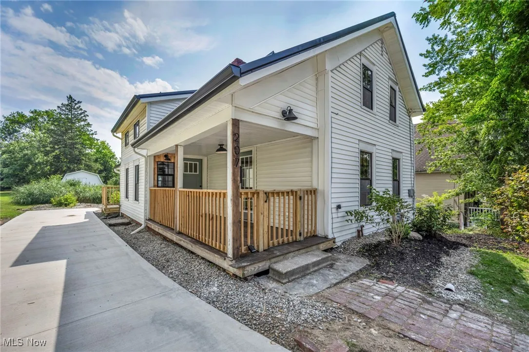 View of side of home featuring covered porch.