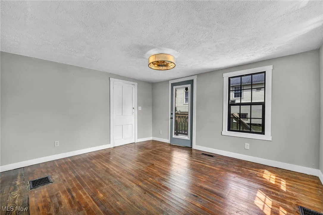 Spare room featuring a textured ceiling and hardwood / wood-style flooring