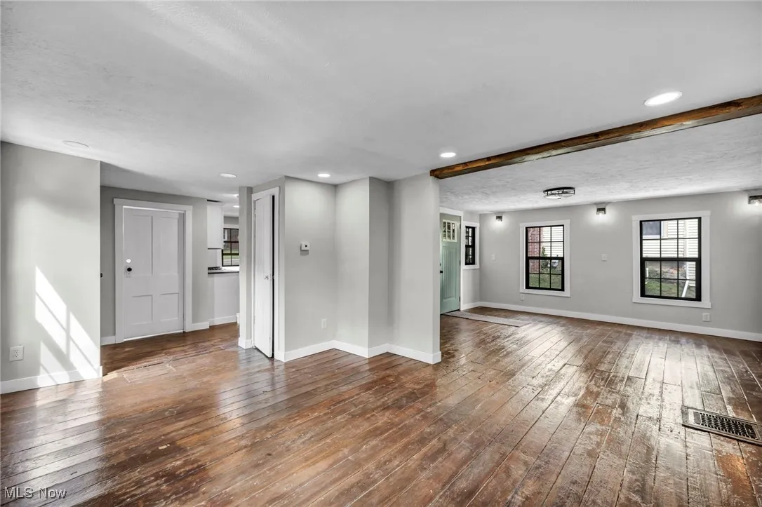 Spare room featuring hardwood / wood-style floors, a textured ceiling, recessed lighting, and beamed ceiling
