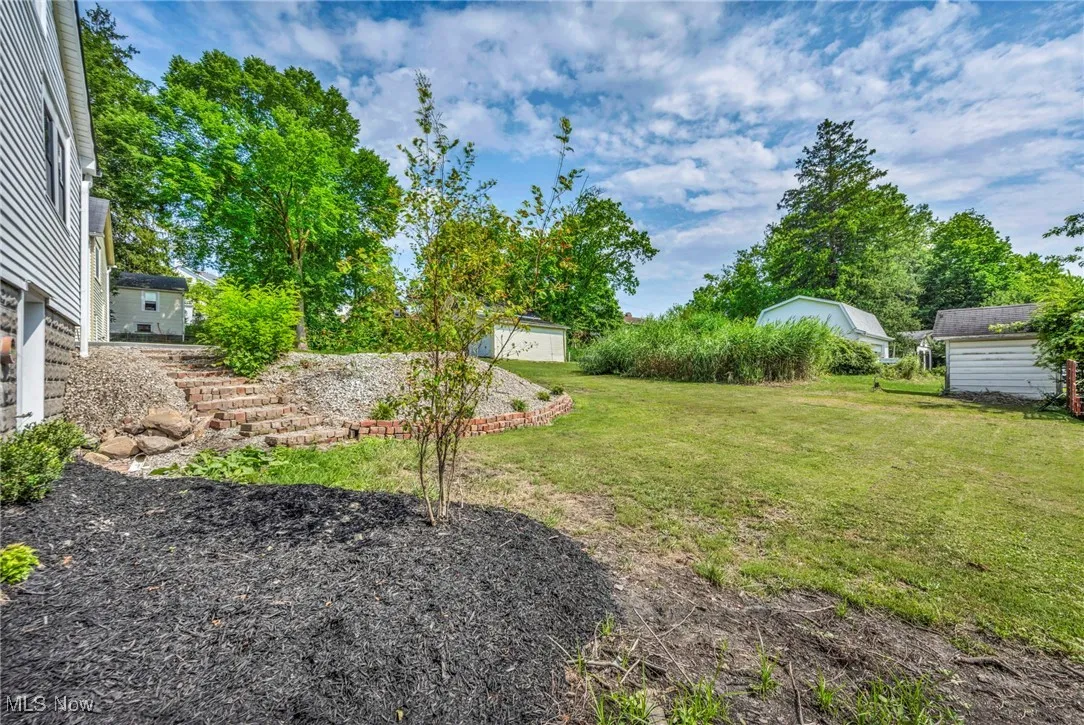 View of grassy yard featuring a shed