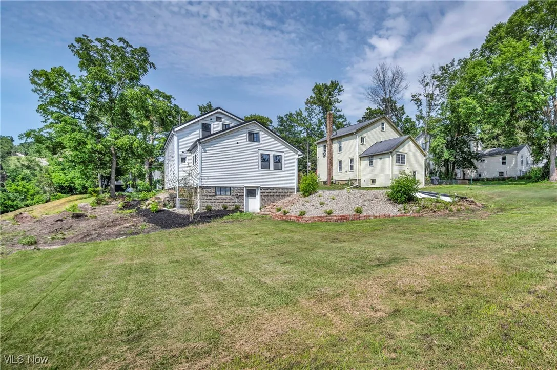 Rear view of house featuring a yard