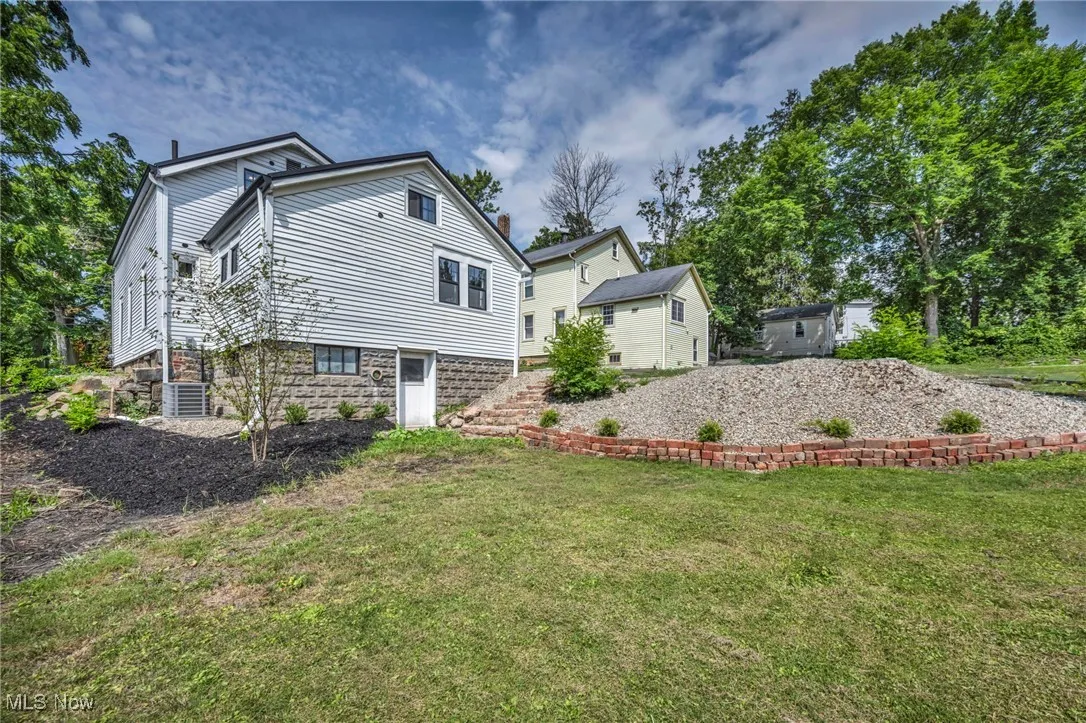 Rear view of property with a lawn