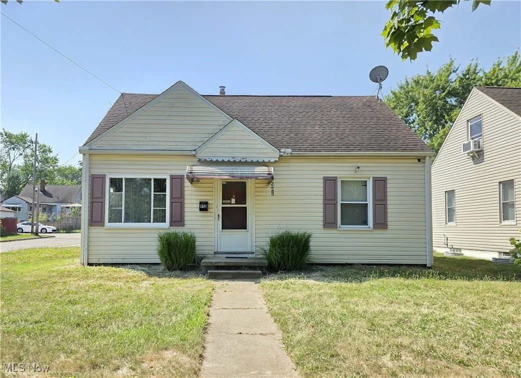 Bungalow featuring a front yard and a shingled roof