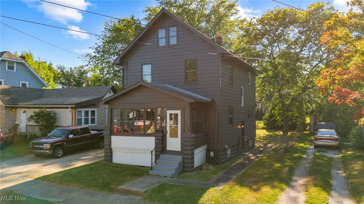 View of front facade featuring driveway, a chimney, a front yard, and entry steps