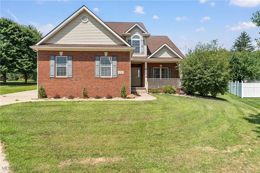 View of front of house featuring a front yard, brick siding, and roof with shingles
